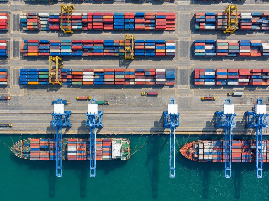 Aerial view of a container port with cranes and organized shipping containers